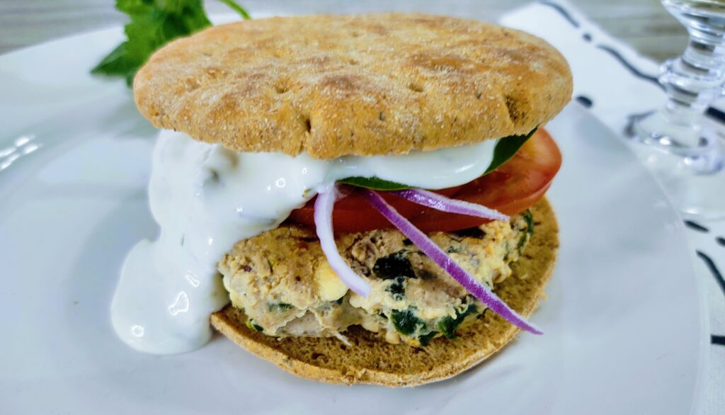 a prepared Mediterranean turkey burger on a white plate