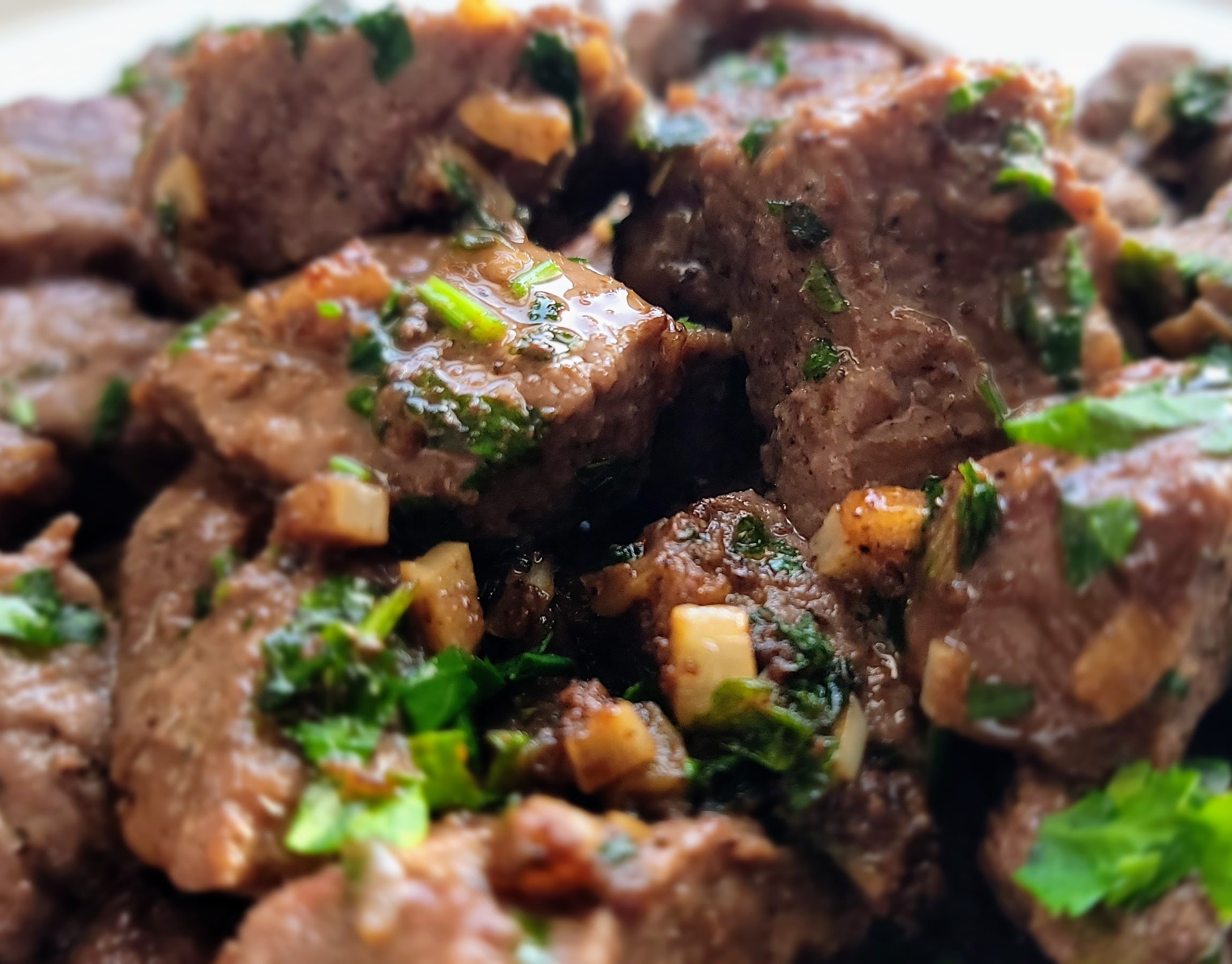 cooked steak bites with garlic, butter and parsley.