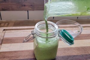 creamy cilantro lime dressing being poured into a jar
