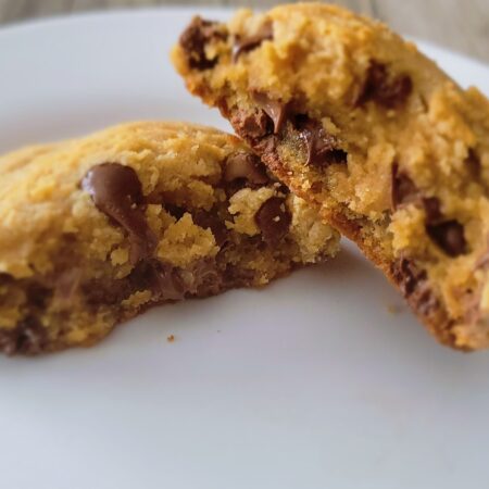 a pulled apart peanut butter chocolate chip cookie on a white plate.